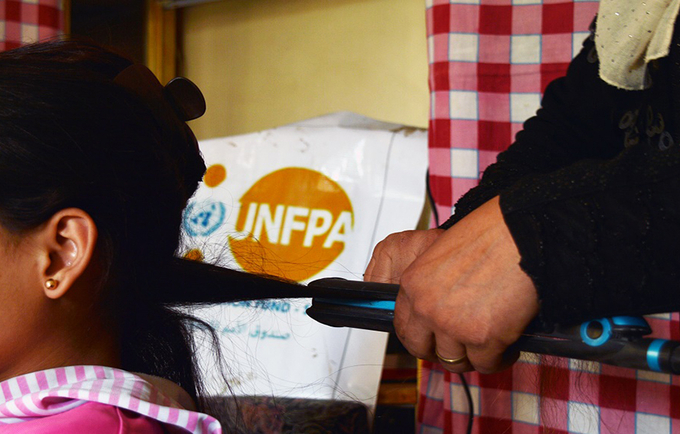 Hind beautifies her daughter’s hair at her  beauty shopr.  UNFPA - Syria 2022