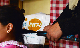 Hind beautifies her daughter’s hair at her  beauty shopr.  UNFPA - Syria 2022