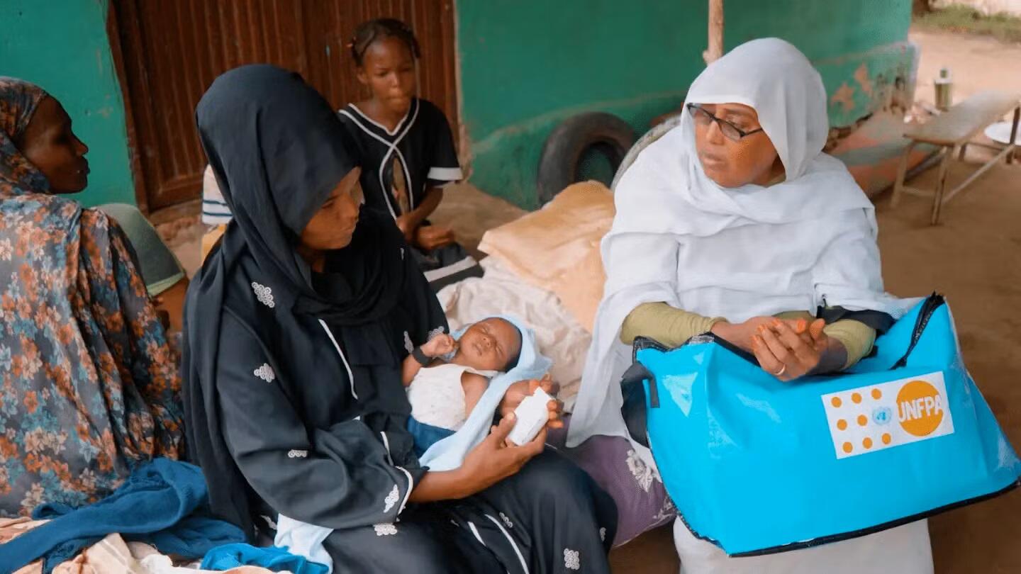 Health Visitor Awatef Othman Hassan provides care and support to Laila, a young mother with her newborn, at a shelter for displaced people in Wad Madani City, Sudan. Both are displaced from fighting in Khartoum. Credit: © UNFPA Sudan