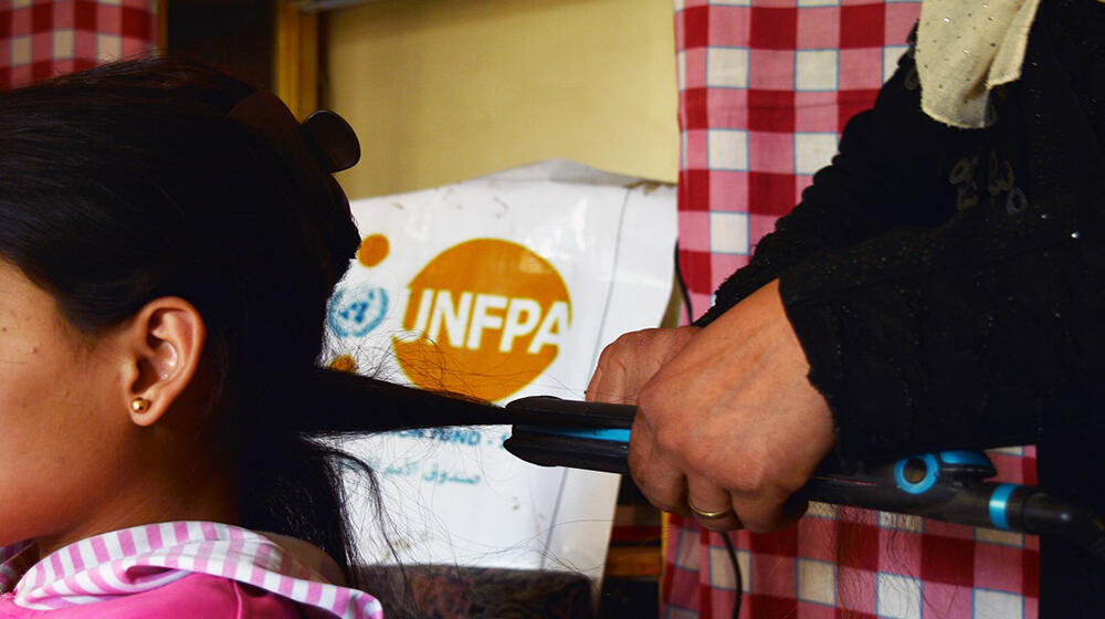 Hind beautifies her daughter’s hair at her  beauty shopr.  UNFPA - Syria 2022